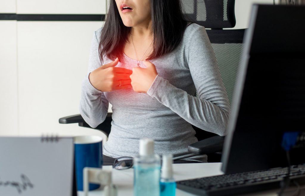 Asian woman having or symptomatic reflux acids during working at home