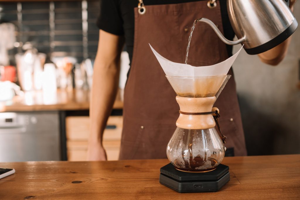 cropped view of barista preparing pour-over coffee using Chemex Coffeemaker