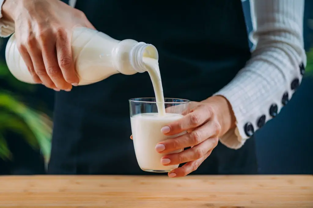 Pouring Kefir into glass